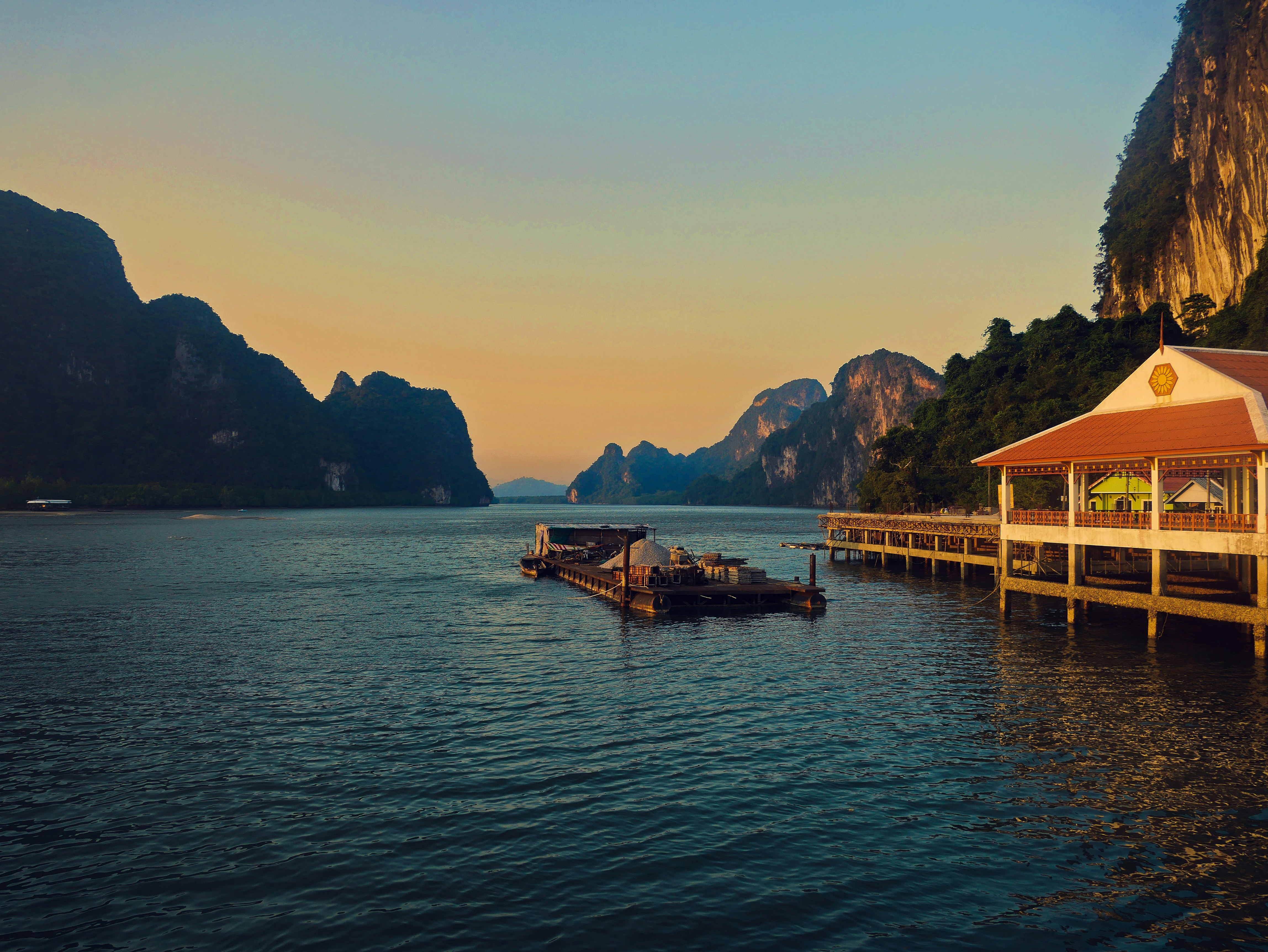 floating restaurant on body of water near mountains